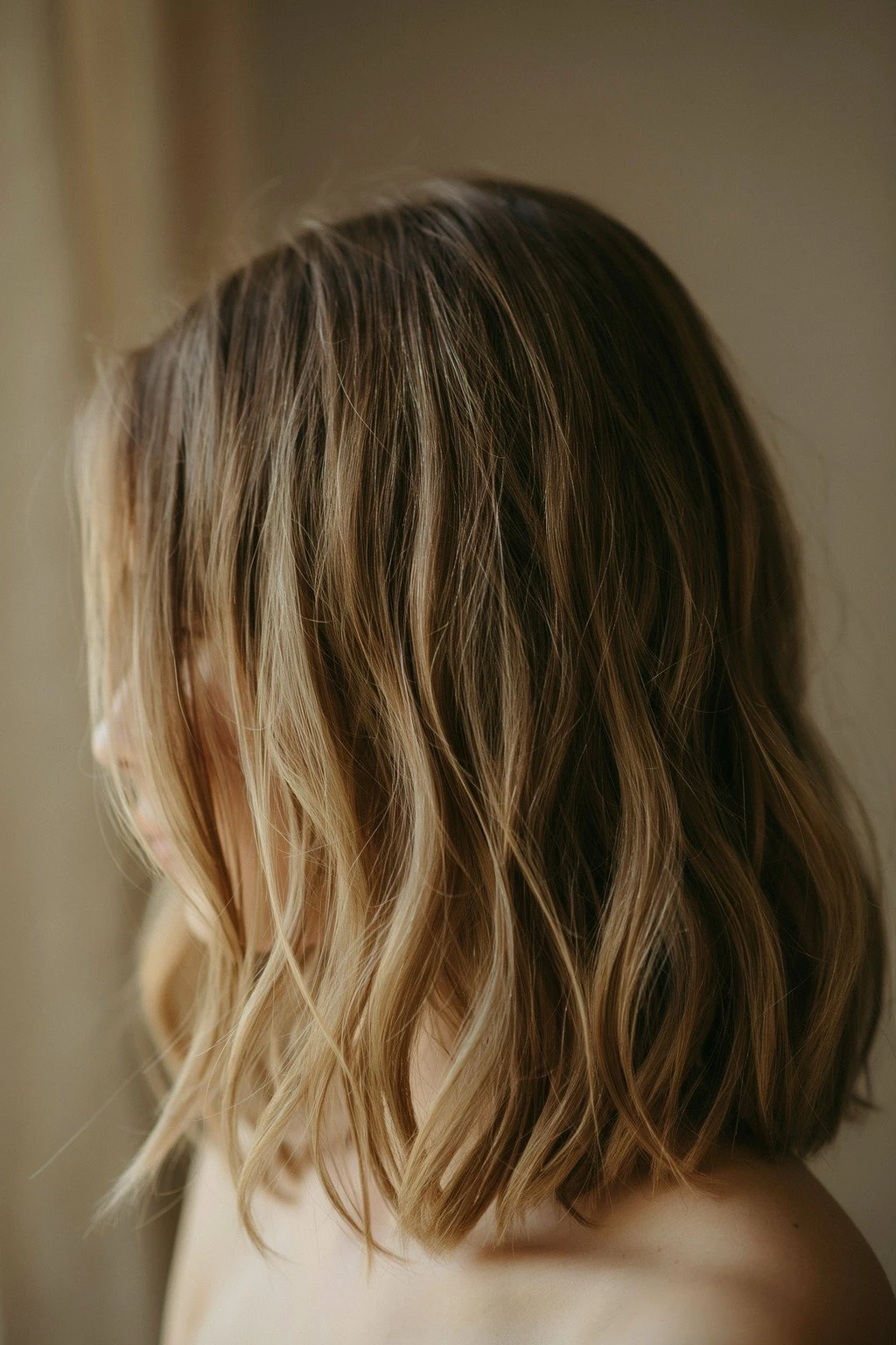 Medium brunette hair with soft caramel and honey-toned ribbons through the mid-lengths, root left soft