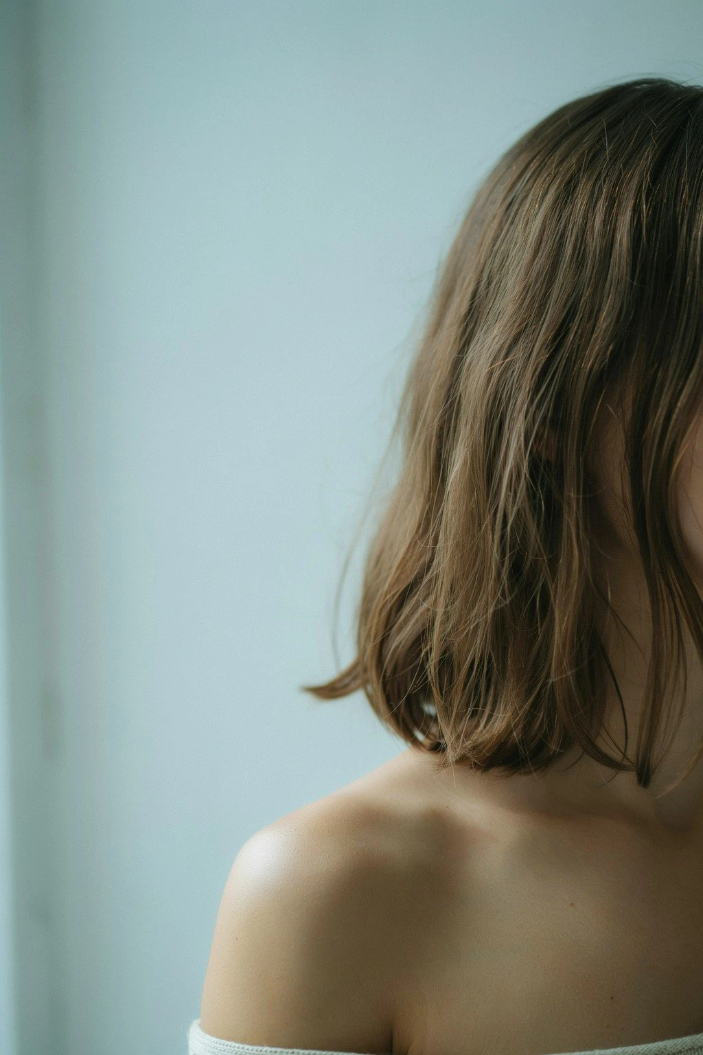 Medium brunette hair toned to a cool mushroom-brown finish, neutral and slightly smoky in natural light