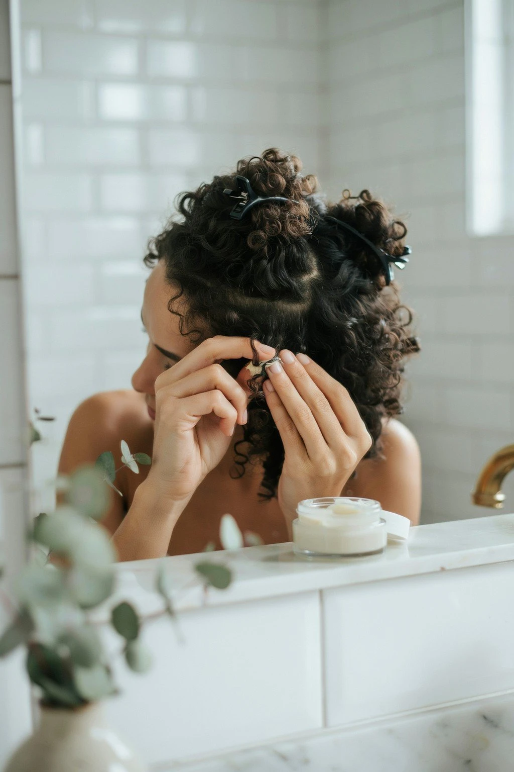 Woman applying product to curly hair in sections