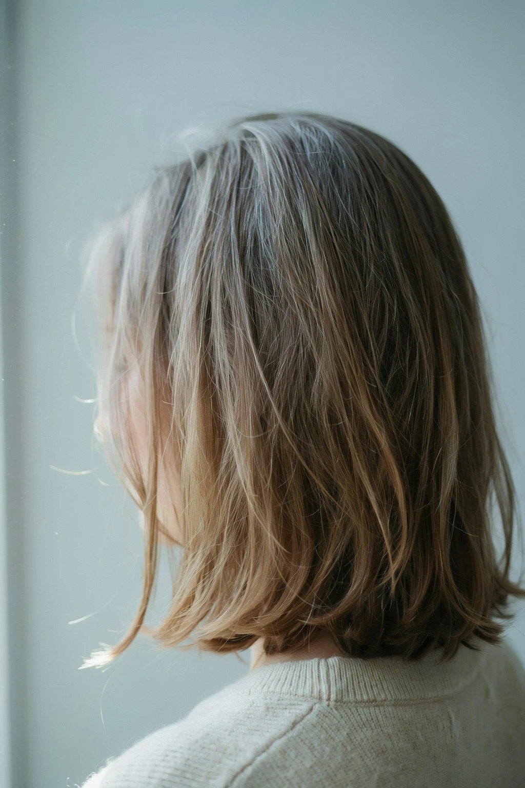 Three views of the same length of hair showing early blending, mid grow-out, and mostly silver stages of a transition
