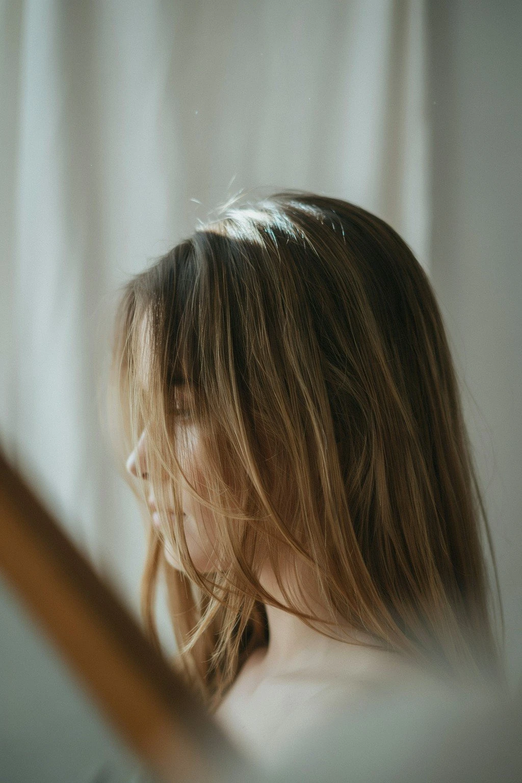 Woman with long layered hair and face-framing pieces around the cheekbones