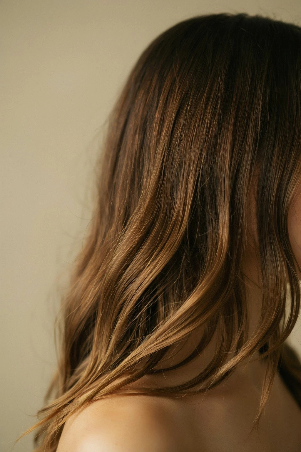 Brunette hair with a rich caramel-to-honey gradient catching directional light, warm and saturated